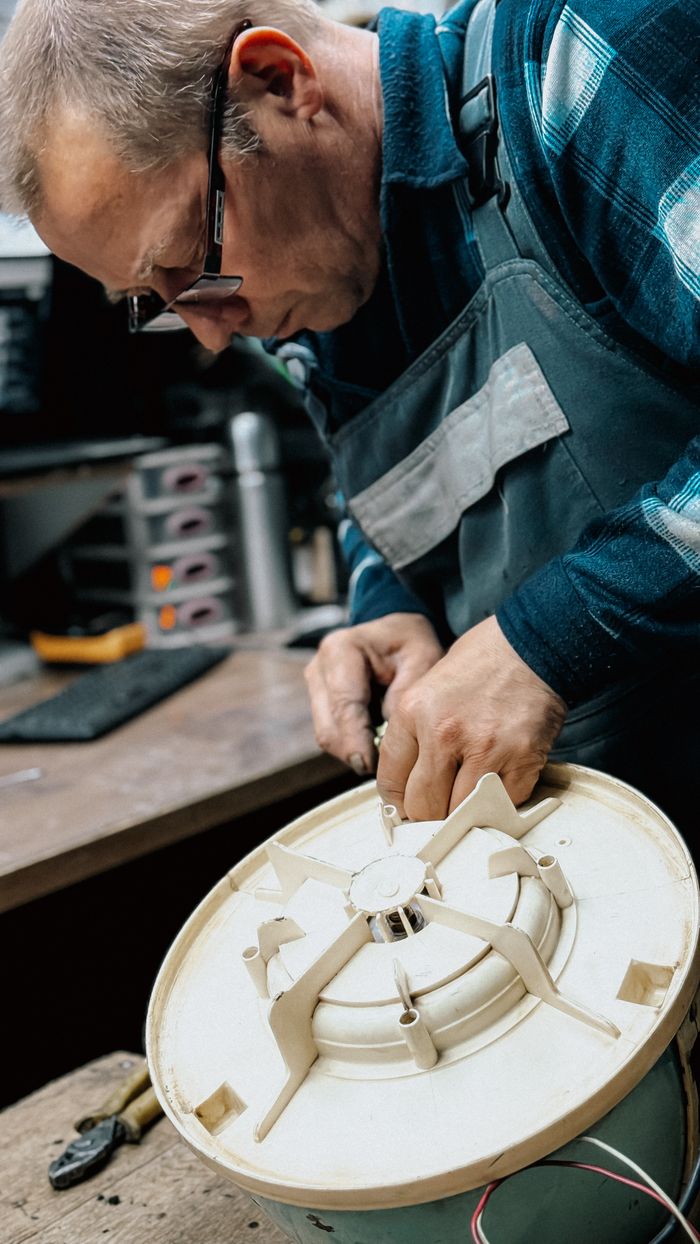 Mastering the First Impression: Your intriguing post title goes here An experienced technician repairing a component of a home appliance on a workbench.