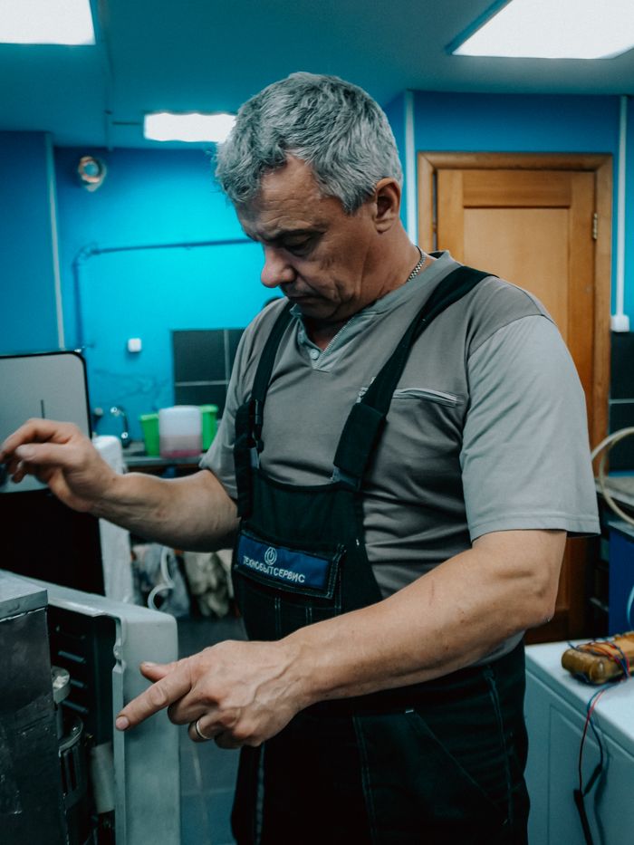 Experienced technician troubleshooting equipment in an indoor workshop.