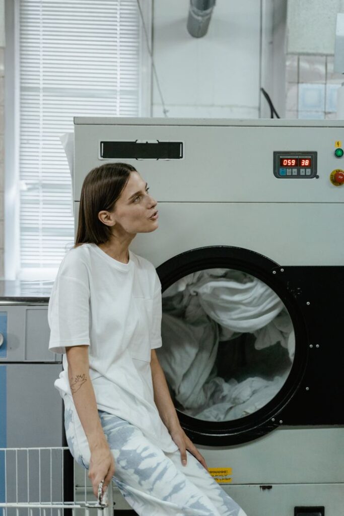 The Art of Drawing Readers In: Your attractive post title goes here Woman sitting by washing machine in a bright, modern laundromat. Casual and relaxed atmosphere.